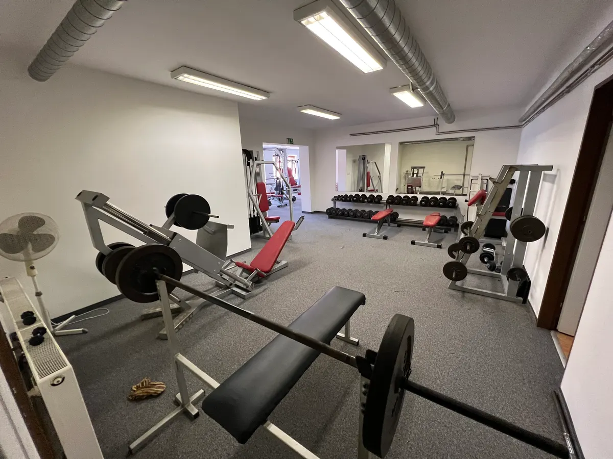Činky a posilovací stroje ve fitness centru